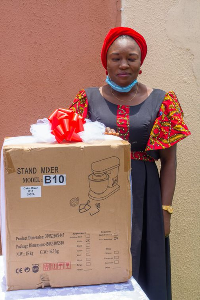 A woman receiving a stand mixer as part of the Women Empowerment programme
